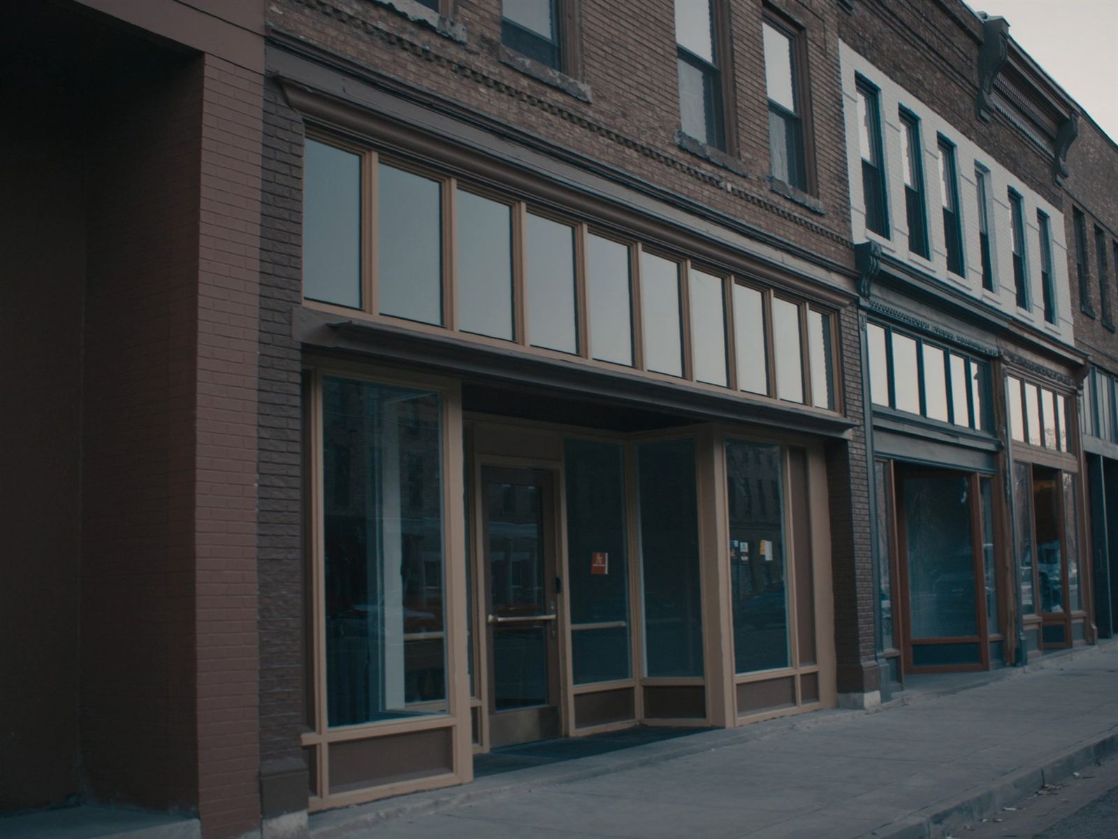The brick and glass storefront of a small professional services office on a quiet main street
